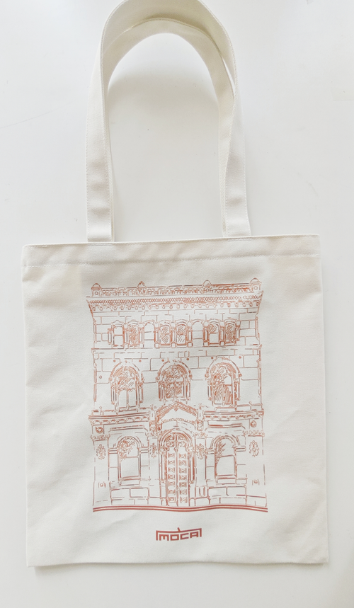 Natural-coloured tote bag with a red line drawing of MOCA's heritage building and the red MOCA wordmark.